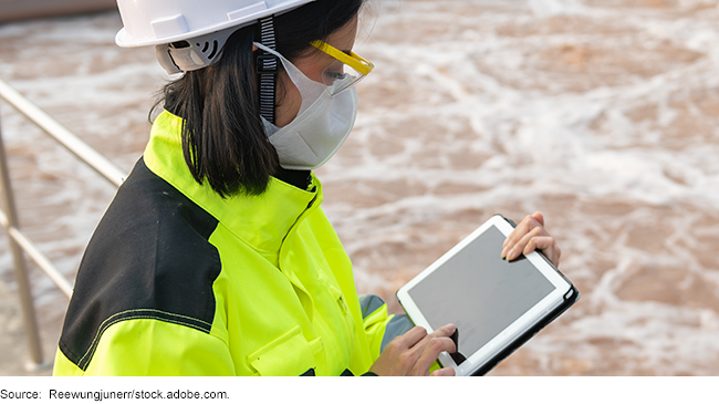 Worker using a tablet at a wastewater treatment plant