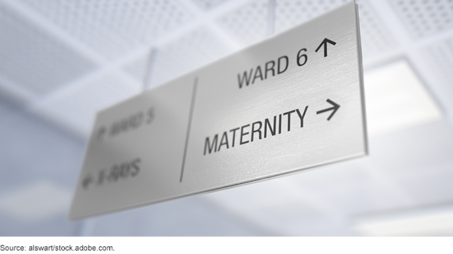 Direction sign hanging from a ceiling with an arrow pointing to maternity