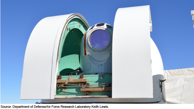 Military laser weapon against a blue sky