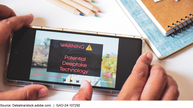 a person's hands holding a smartphone that displays a warning message "Warning! Potential Deepfake Technology" 