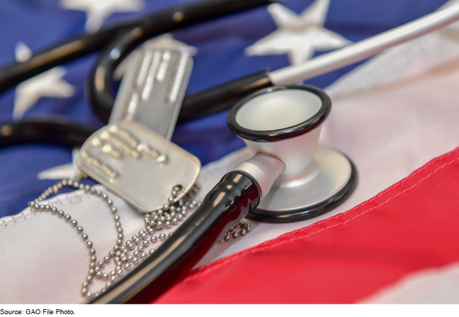 A stethoscope and military ID tags laid on a U.S. flag.