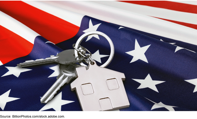 keys on a metal keychain in the shape of a house resting on an American flag