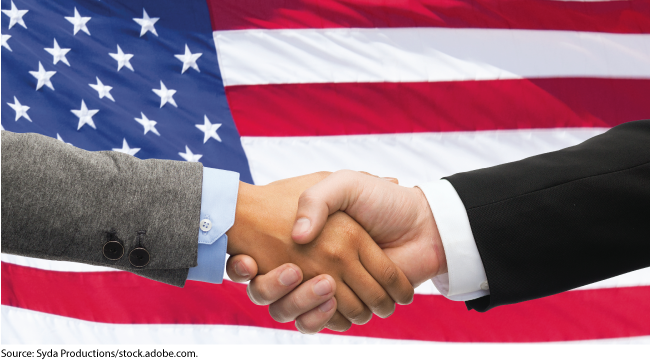 Handshake in front of a U.S. flag