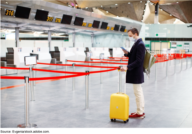 Person standing alone in an airport check-in area. 