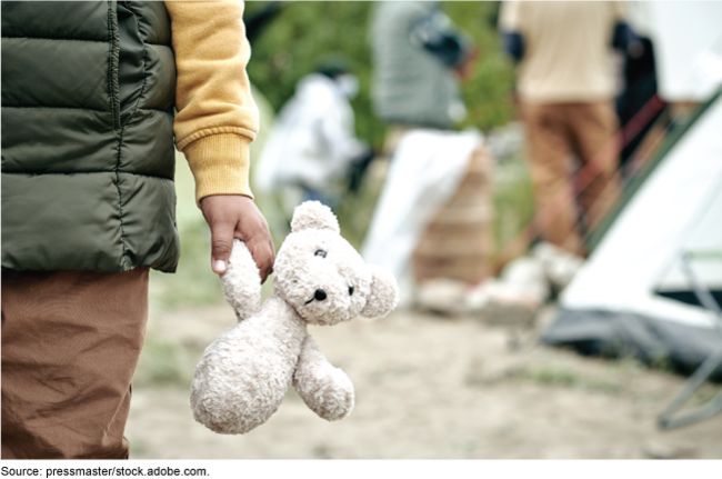 A young child holding a stuffed animal.