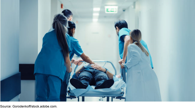 Man on a stretcher accompanied by healthcare professionals in a hospital