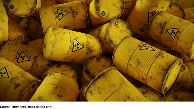 An image of several yellow hazardous waste barrels marked to indicate radioactive material. 