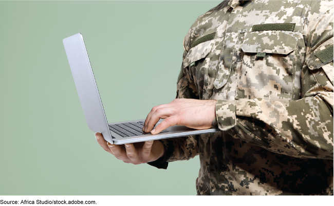 uniformed servicemember on a laptop