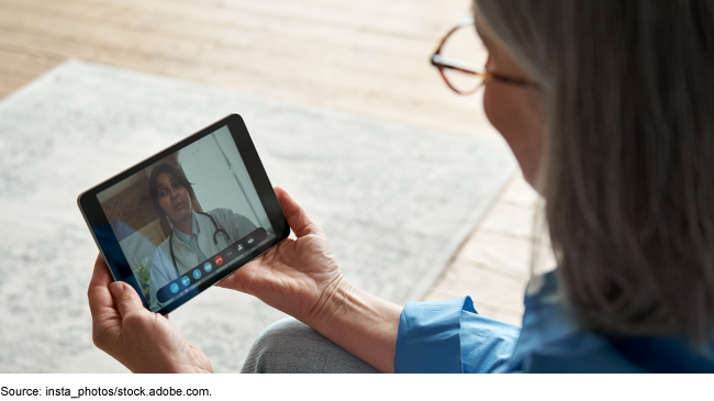 An older woman having a telehealth visit with medical personnel using a tablet.