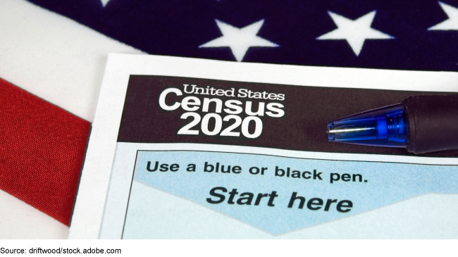 A packet sitting on top of the American flag, with text: United States Census 2020, use a blue or black pen, start here. 