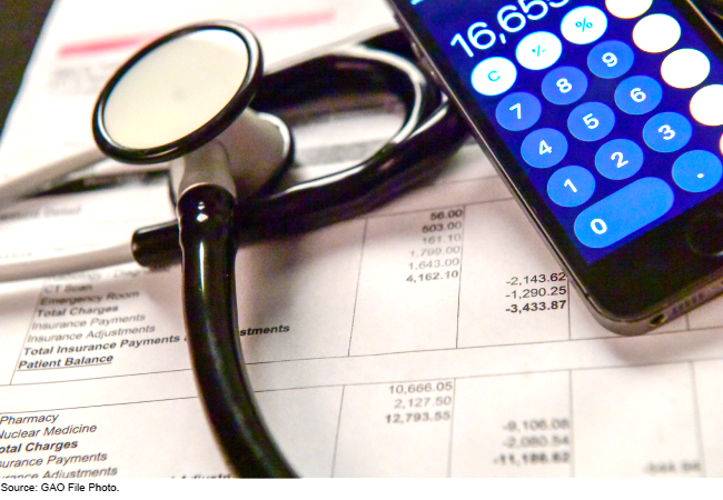 Stethoscope atop medical bills