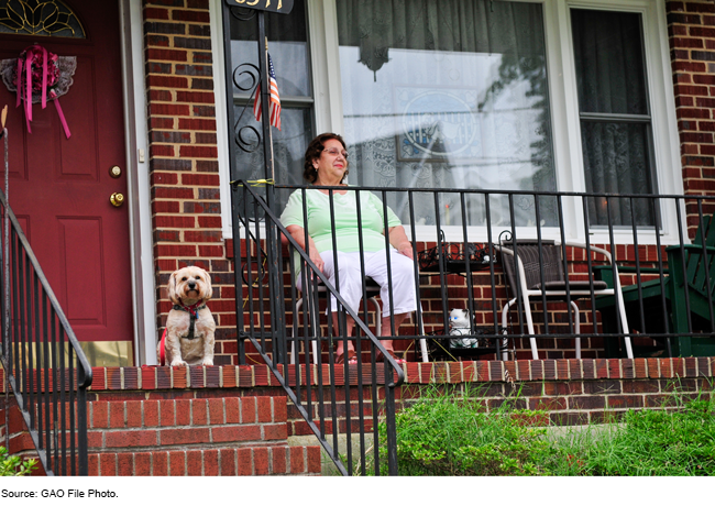 A woman on a porch with a dog.