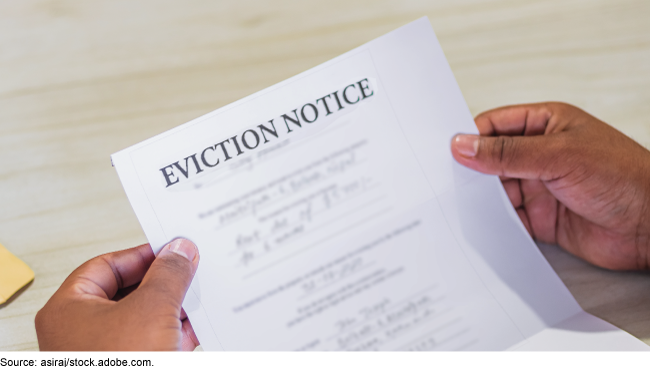 Pair of hands holding an eviction notice. 