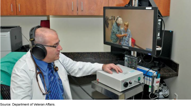 A medical professional looking at a screen providing telehealth services to a patient