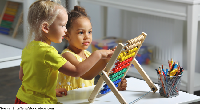 Two children playing with a wooden toy