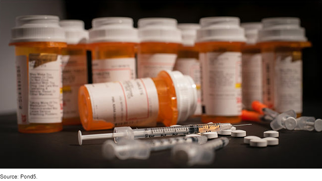 Prescription drug bottles and syringes on a table