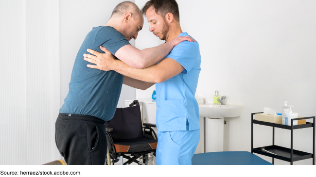 Medical professional helping a person to stand