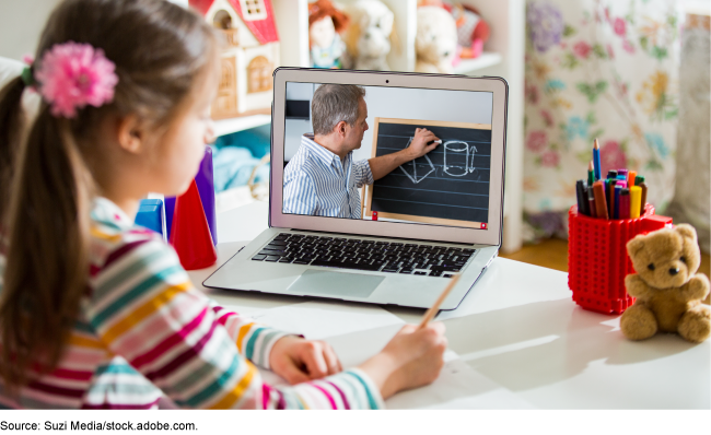 A young student participating in virtual learning via a laptop