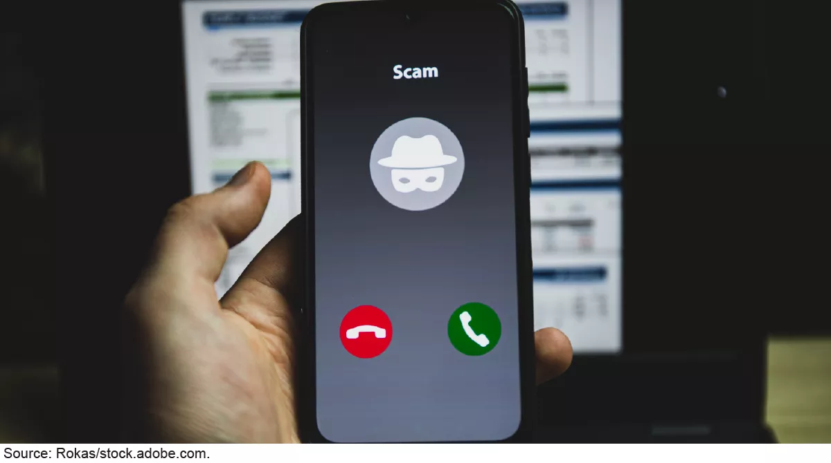 Illustration showing a cellphone in someone's hand. There's an incoming call labeled "SCAM."