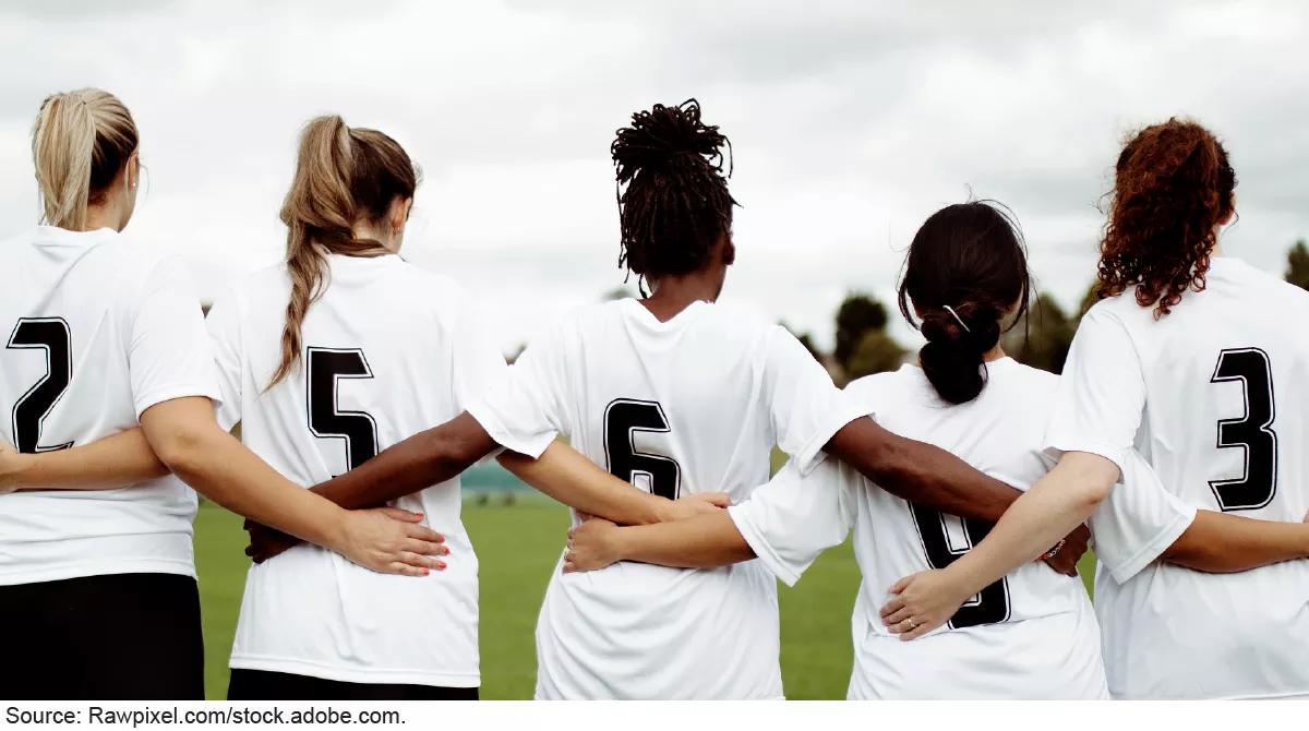 Stock image showing 5 women in soccer jerseys linking arms