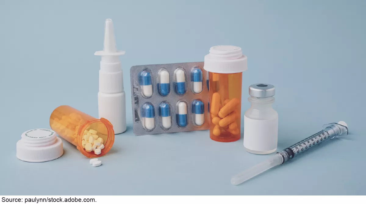 Stock image showing several forms of prescription drugs including pills, nasal spray, capsules, and injectables. 
