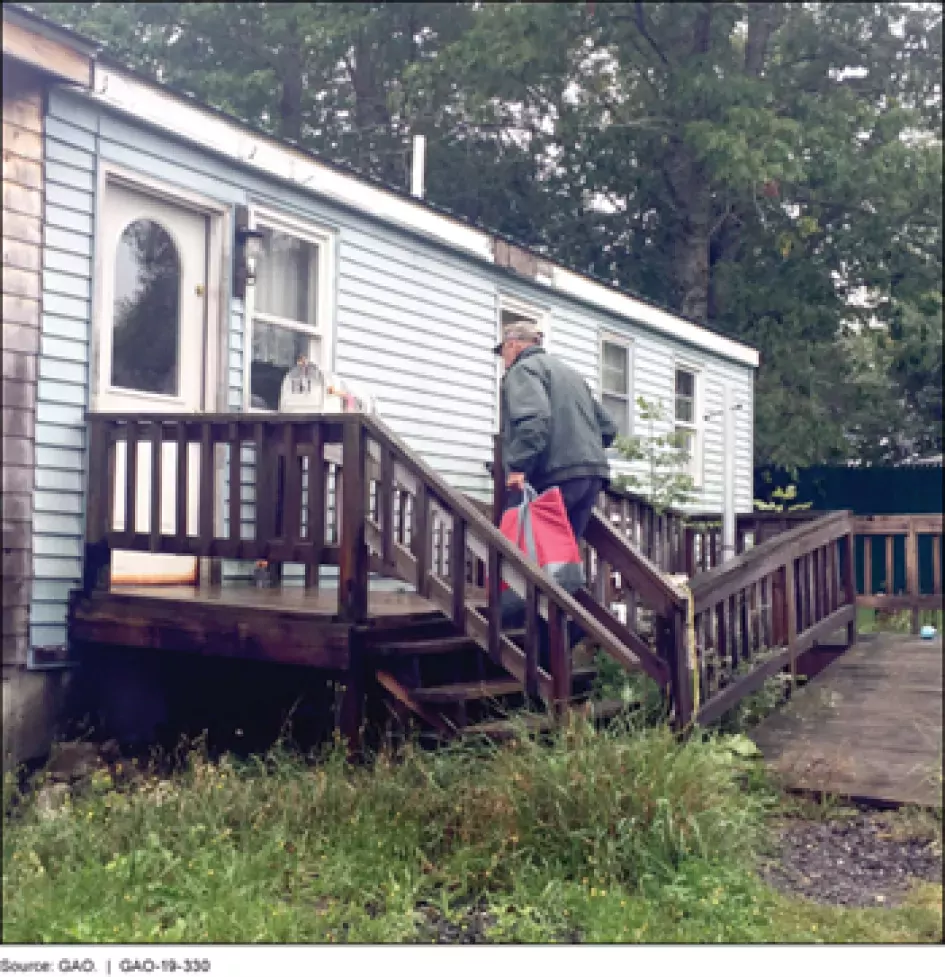Photo of a volunteer delivering meals to a home in rural Maine. 