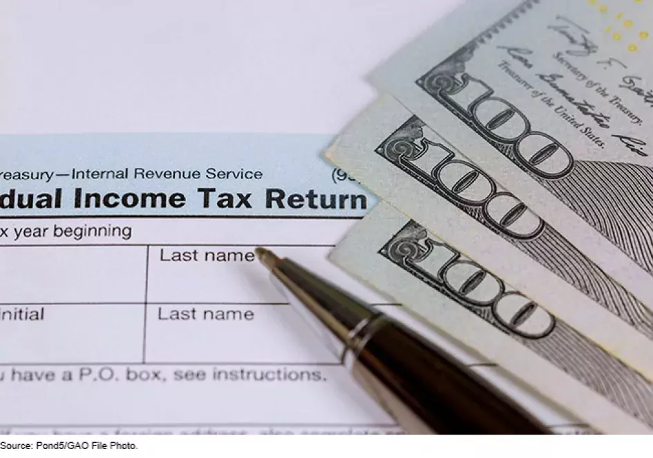 Photo of a income tax return form and 100 dollar bills