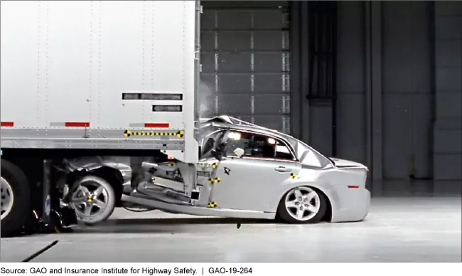 Image showing a controlled, simulated car crash under a truck