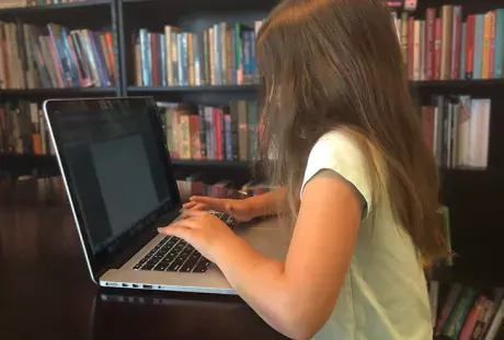 A child uses a laptop at home