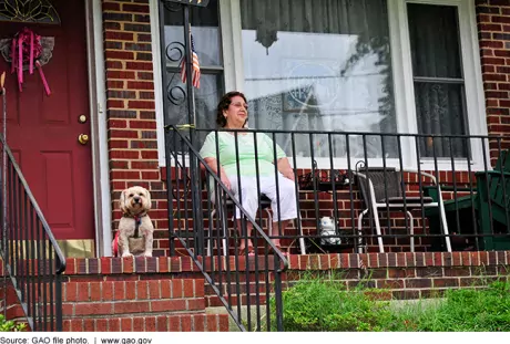 Photo of an older woman sitting on her front porch. 