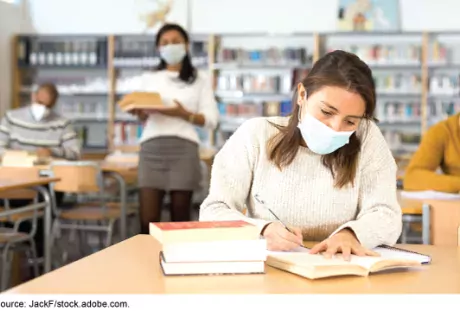 College students in library with masks on.