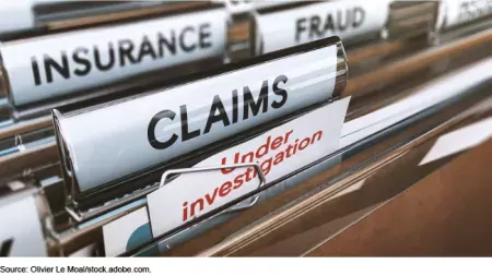 Photo showing a filing cabinet folders marked "fraud," "Insurance," Claims" and "Under Investigation"