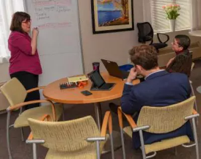 A group of people working at a whiteboard