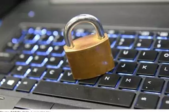 Photo of a padlock on a computer keyboard. 