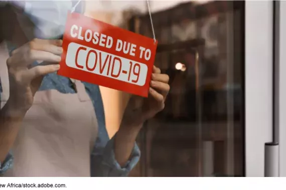 Photo of a "Closed for COVID" sign in a business window