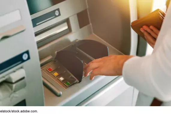 Image of someone taking out money at an ATM