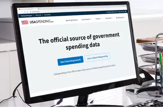 Illustration showing the USASpending.gov website on a desktop computer screen.